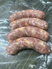 fresh bratwurst with cheddar on a clear plastic surface