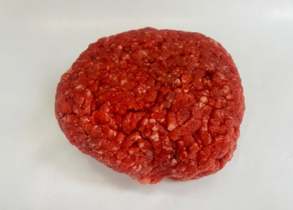 Raw ground beef patty on a white background