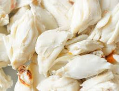 pieces of jumbo lump crab meat against a white butcher paper